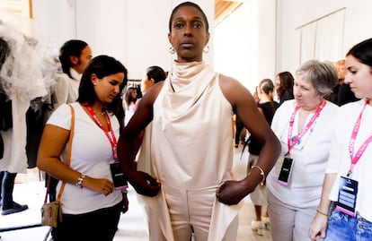 Asistentes al desfile de Alberto Puras, creador de la firma Puras, se acercan a la modelo para contemplar su vestido al detalle.