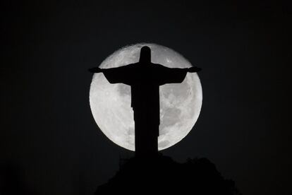 La silueta de la estatua del Cristo Redentor se proyecta en la luna llena en el cielo de Río de Janeiro, Brasil.