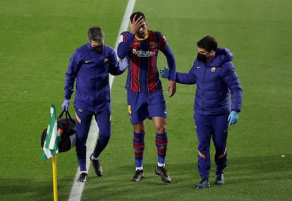 Ronald Araújo abandona el terreno de juego lesionado, durante el partido contra el Betis en el estadio Benito Villamarín, en Sevilla.