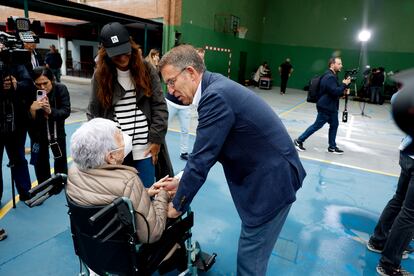 El presidente del Partido Popular, Alberto Núñez Feijóo conversa con una mujer tras votar en el colegio electoral del Ramiro de Maeztu en Madrid.