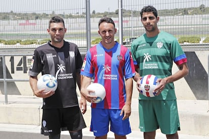 David Barral (i), Jordi Xumetra (c) y el defensa Issam El Adoua posan con las tres indumentarias del Levante en su puesta de largo.