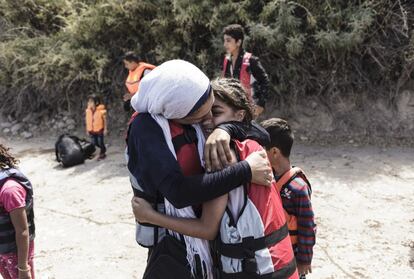 Dos inmigrantes se abrazan al llegar a una playa de la isla griega de Lesvos después de cruzar el mar Egeo que separa Turquía de Grecia.