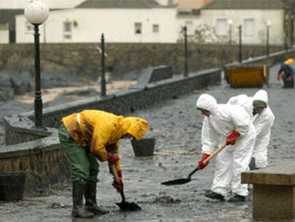 Trabajadores de la empresa pública Tragsa limpian la nueva oleada de fuel del <b></b><i>Prestige</i> llegada a Muxía (A Coruña).