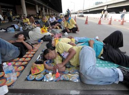 Militantes del APD descansan a las puertas del viejo aeropuerto de Bangkok, donde se ha refugiado el Gobierno tras la toma de la sede del Primer Ministro el pasado agosto