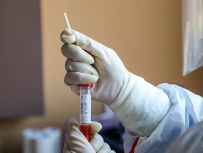 Un miembro de un equipo médico en Wuhan toma una muestra de una persona para analizarla en laboratorio.