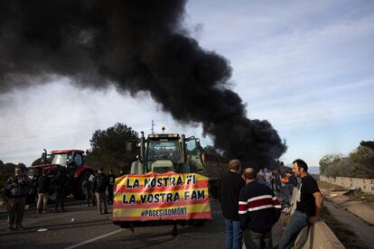 Una columna de humo se eleva en la autopista AP-7 en Pontós (Girona), durante el corte de los payeses este miércoles.