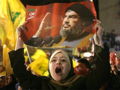 Una joven porta una pancarta con el líder de Hezbolá, Hassan Nasralá.