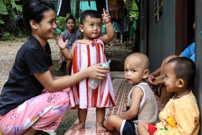 Hla Hla Win fuma un cigarro mientras Kay Myant Myant Lwin juega con su hija, en el refugio para mujeres de Freedom Restoration Project, en Mae Sot, Tailandia, en agosto de 2022.