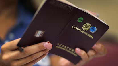 Una mujer sostiene su pasaporte de Colombia.