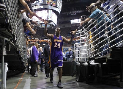 Kobe Bryant choca las cinco con los aficionados al abandonar la pista de Nueva Orleans como el jugador más joven de la NBA en superar los 30.000 puntos.