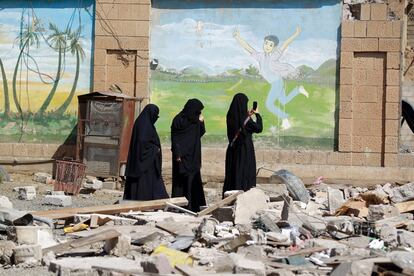 Unas mujeres fotografían los daños causados en una escuela tras un ataque aéreo perpetrado por la coalición liderada por Arabia Saudí, en Saná, Yemen.