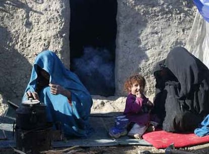 Dos refugiadas afganas y una niña, en la puerta de una chabola en Kabul.