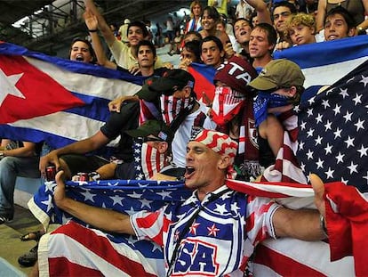 Seguidores de Cuba y Estados Unidos posan con banderas de sus países en las gradas del estadio cubano.