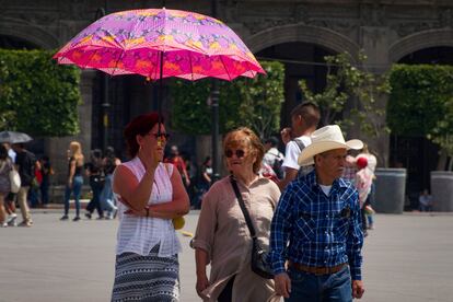  La tercera ola de calor del año seguirá ocasionando altas temperaturas al menos durante el resto de esta semana, a la espera de las nuevas predicciones de los servicios meteorológicos nacionales. En la imagen, peatones se resguardan de los rayos del sol bajo la sombra de sombreros y sombirllas, en Ciudad de México. 