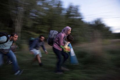 Un grupo de refugiados corre campo a través en un intento de evadir la policía húngara cerca de la frontera de Serbia.