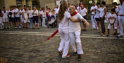 Una joven baila con un hombre de avanzada edad, en una calle de Pamplona.