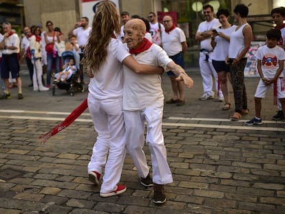 Una joven baila con un hombre de avanzada edad, en una calle de Pamplona.