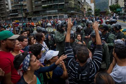 Un grupo de personas manifiestan contra miembros de la Guardia Nacional Bolivariana en Caracas en protesta por la carest&iacute;a.