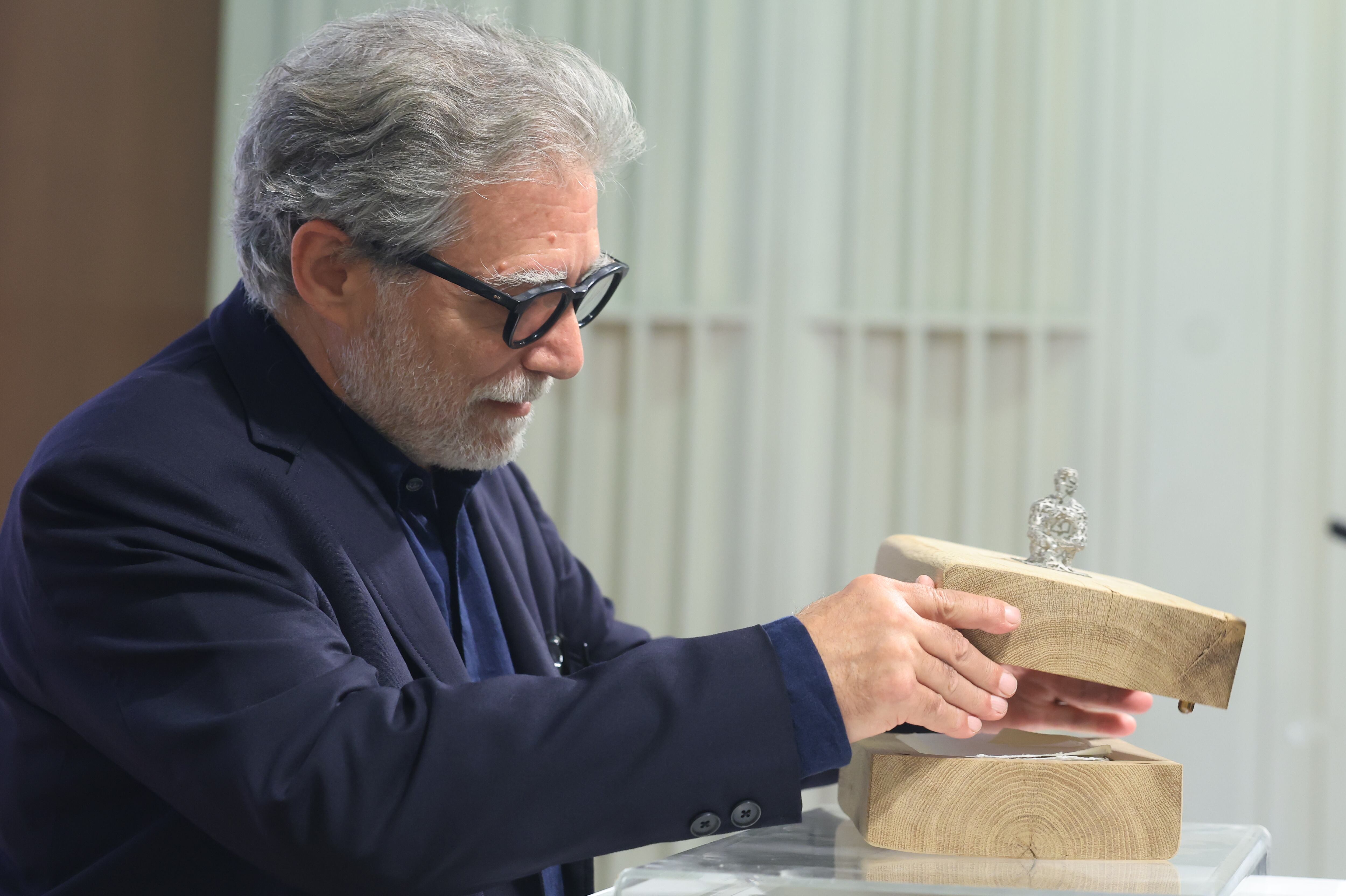 Plensa abre el estuche de madera de roble de su obra 'Utopía?'.