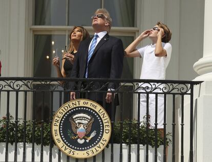 Donald Trump, su mujer, Melania, y su hijo Barron, observan el eclipse solar desde el balcón de la Casa Blanca.