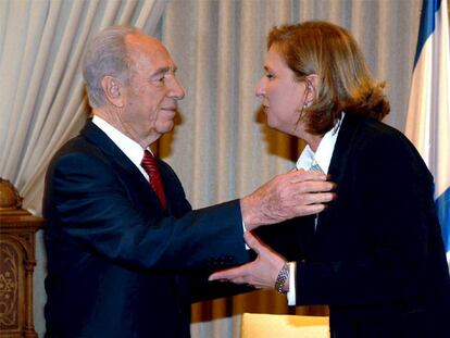 El presidente israelí, Simon Peres, saluda a la ministra de Exteriores y líder de Kadima, Tzipi Livni, en Jerusalén.