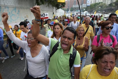 Partidarios de la oposición gritan consignas mientras bloquean una autopista durante una protesta contra el gobierno del presidente venezolano Nicolás Maduro en Caracas.