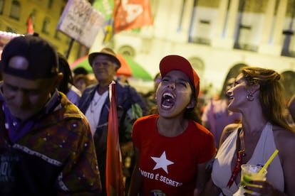 Una votante de Lula da Silva reacciona mientras las personas se reúnen al cierre de las casillas.