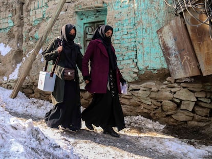 Dos mujeres caminan por las calles nevadas de Kabul para llevar vacunas contra la polio, el pasado 25 de enero.