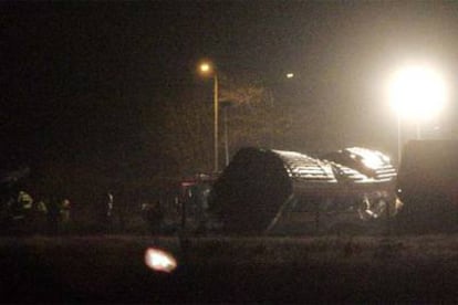 Equipos de emergencia, alumbrados por un potente foco, trabajan en los restos de unos vagones del tren que descarriló anoche en Reading.