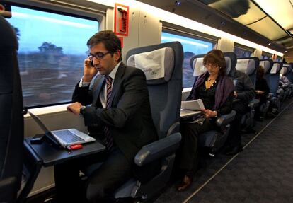 La línea de alta velocidad entre Madrid y Barcelona se estrenó a 300 kilómetros por hora. Los primeros trenes Siemens S-103 salieron a las 06.00 de la mañana desde ambas ciudades y llegaron a sus destinos con adelanto. Un pasajero habla por un teléfono móvil mientras trabaja con un ordenador portátil.