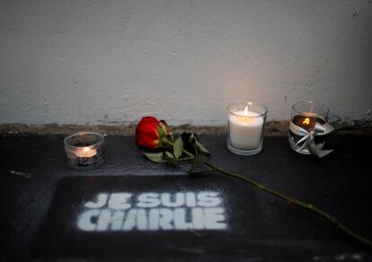 Flores y velas en la puerta de la antigua oficina del periódico satírico 'Charlie Hebdo', en París (Francia), en el quinto aniversario del ataque ataque terrorista contra su redacción, este miércoles.