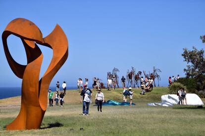 Un grupo de visitantes camina entre varias obras de la exposición 'Sculpture by the Sea'.