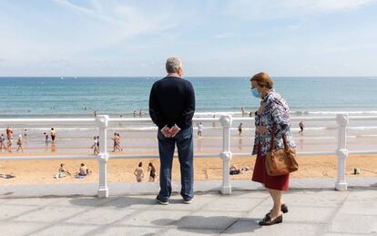 Dos personas utilizan una mascarilla en un paseo por Gijón (Asturias), el pasado verano.