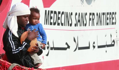 Una persona migrante con un bebé en brazos sale de un barco de Médicos sin Fronteras en el puerto de Salerno, Italia, el pasado 14 de julio. En el mismo buque llegaron 935 migrantes más, incluidos 16 niños y siete embarazadas.