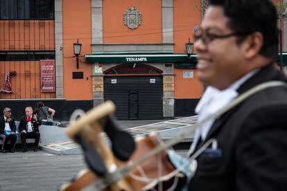 Gabriel Ramírez, que lleva más de 20 años tocando en la plaza Garibaldi, sostiene su guitarrón frente al salón Tenampa.