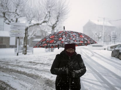 Una mujer se protege de la nieve en Castro Caldelas (Ourense), este miércoles. El 112 ha registrado desde la medianoche del lunes hasta las 6 horas de este miércoles 1.277 incidencias vinculadas al el temporal en Galicia, de las que 160 corresponden a la jornada de hoy.