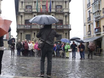 Un grupo de turistas se fotografía frente al Ayuntamiento de Pamplona.