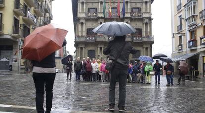 Un grupo de turistas se fotografía frente al Ayuntamiento de Pamplona.