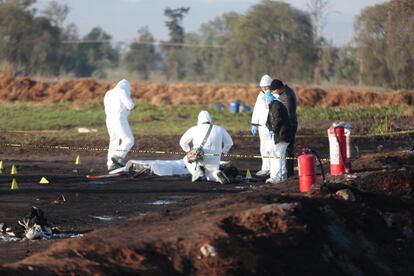 Peritos trabajan en la identificación de los cuerpos que se hallan en el lugar de la explosión.