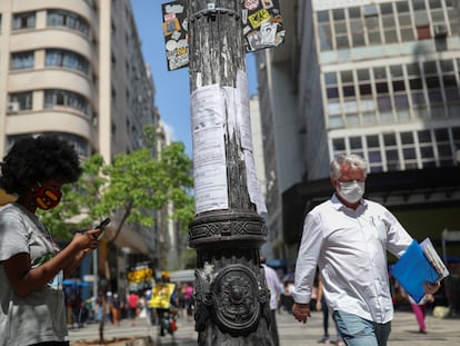 Mulher anota em seu telefone uma oportunidade de emprego a partir de listas postadas em um poste de luz no centro de São Paulo no final de setembro.
