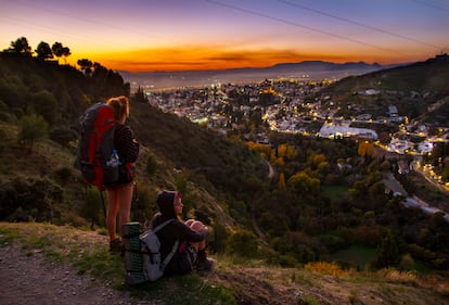 Dos jóvenes al final de una ruta senderista por las montañas de los alrededores de Granada.   