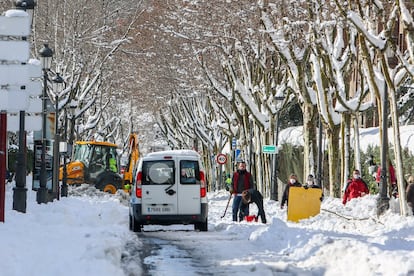 Varias personas despejan una calzada en Pozuelo de Alarcón (Madrid).