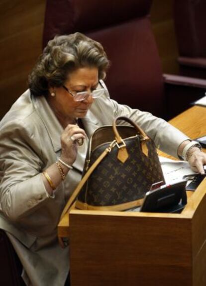 La alcaldesa de Valencia, Rita Barberá, rebusca en su bolso en un pleno de las Cortes.