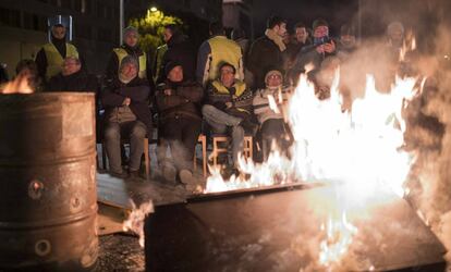 Taxi drivers light bonfires ahead of their night camped outside Ifema.