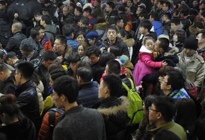 Un hombre besa a una niña entre la multitud que se traslada a sus lugares de origen para celebrar el Año Nuevo Chino. Estación de tren de Harbin (China), el 16 de febrero de 2015.