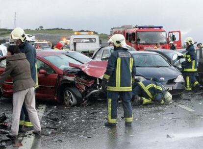 Varios agentes de bomberos en el lugar donde se ha producido la colisión en cadena en la que se han visto implicados 54 vehículos.