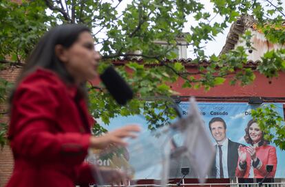 La candidata de Vox, Rocío Monasterio, durante un mitin en Leganés. Al fondo, un cartel con imágenes antiguas de Casado y Díaz Ayuso. 