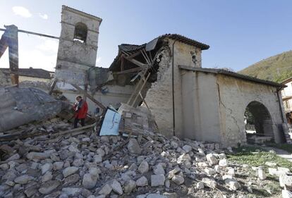 Una fotógrafa camina entre los escombros de iglesia San Antonio en el pueblo italiano de Visso destruida tras el terremoto.