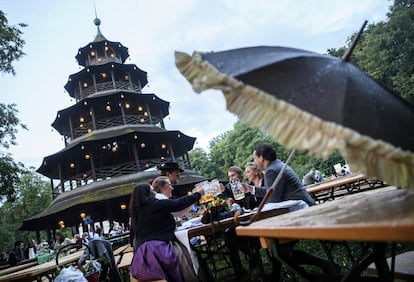 Varias personas beben unas cervezas durante el tradicional 'Kocherlball' en los Jardines Ingleses en Munich, Alemania.