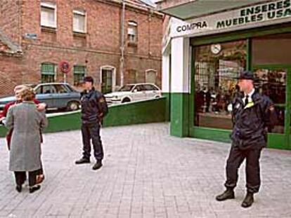 Dos policías custodiaban ayer la tienda de antigüedades Viana 35 tras ser retirado el cadáver de su dueño.